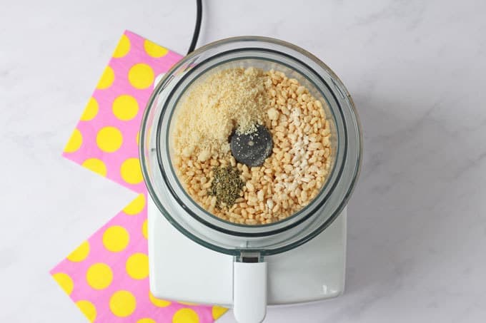 A food processor with Rice Krispies, parmesan, dried oregano and dried garlic powder