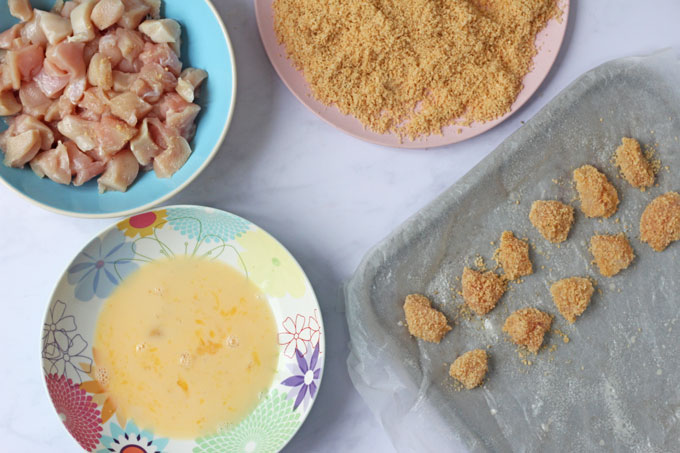 Making Popcorn Chicken with chicken pieces, egg mixture and a Rice Krispie coating