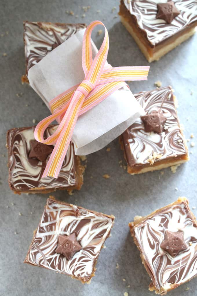 finished and decorated shortbread with one square wrapped in greaseproof paper and tied with a pink and yellow ribbon.