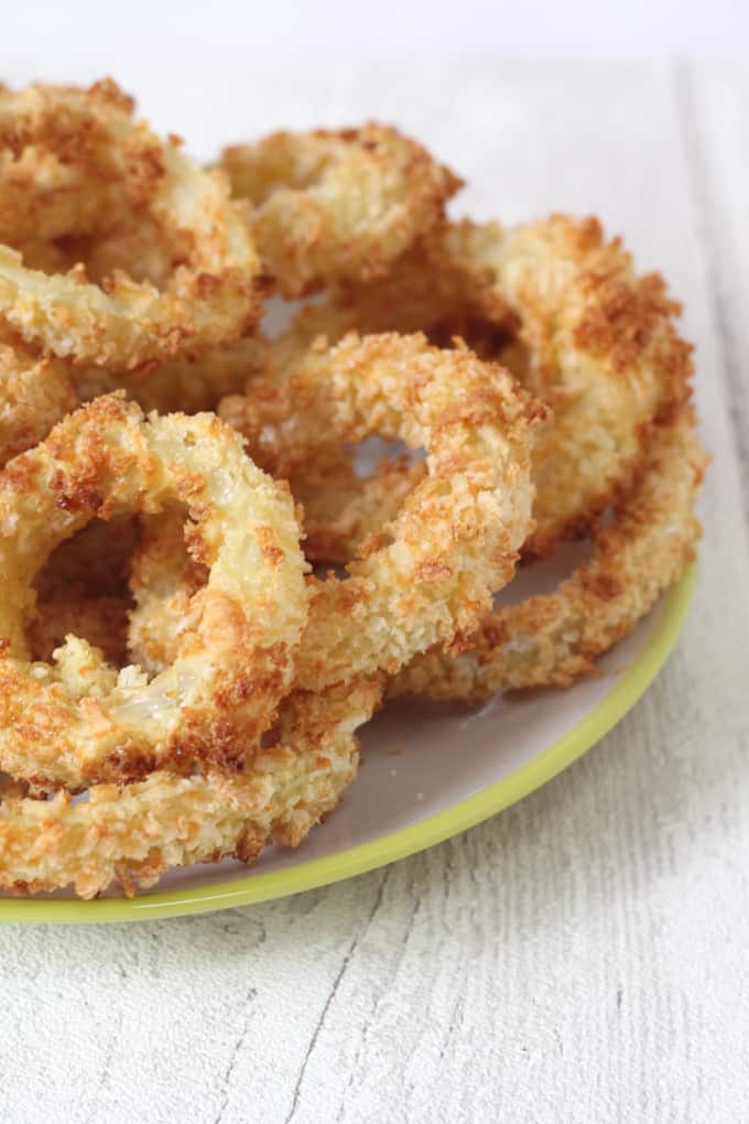 crunchy onion rings in a pile on a white plate