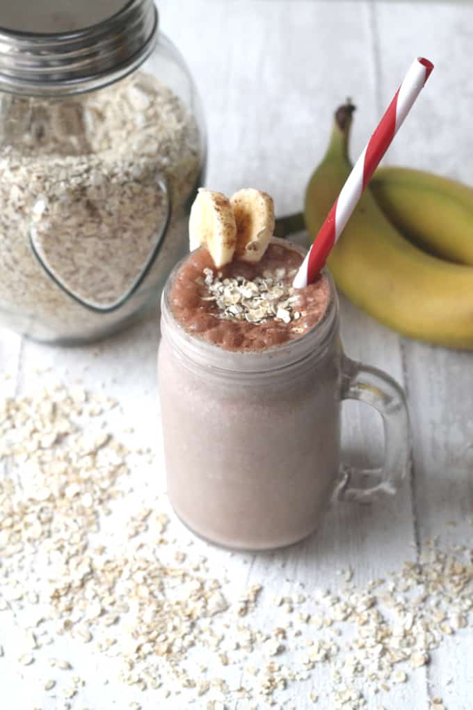 Get your morning off to a healthy but tasty start with this Choco Banana Breakfast Smoothie.served in a glass drink jar with a red & white straw. Garnished with slices of banana and a sprinkle of oats