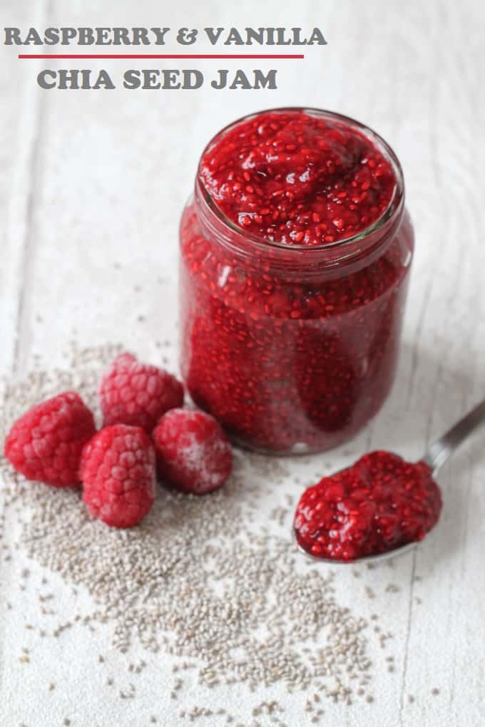 raspberry vanilla chia jam in a glass jar with a teaspoon of jam and some whole fresh raspberries