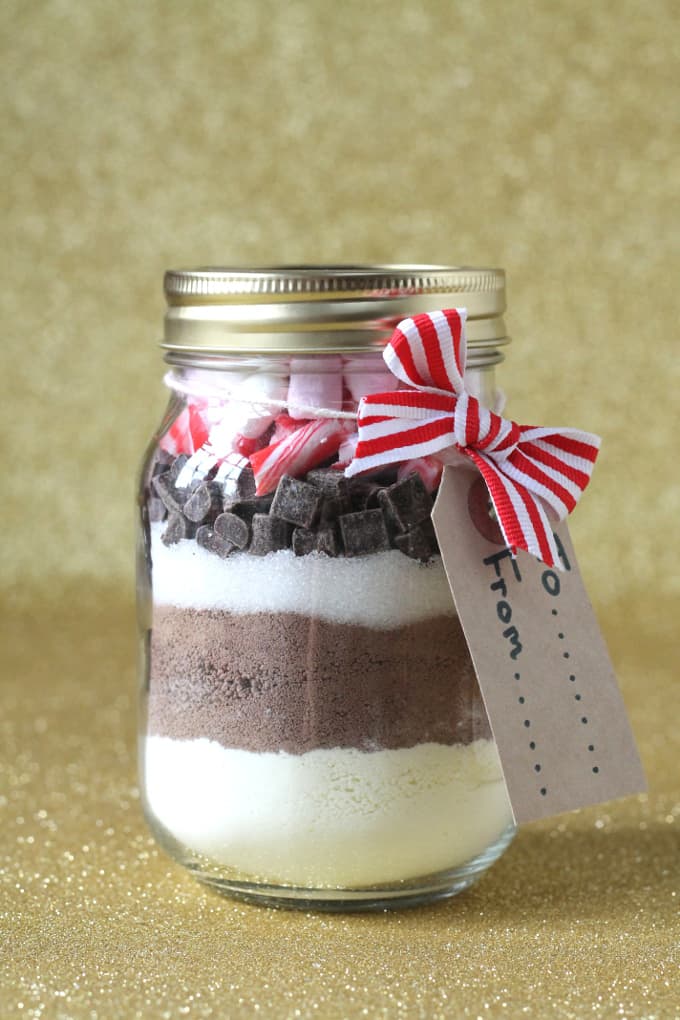 hot chocolate christmas present in a glass jar with a red stripy ribbon and a cardboard gift tag