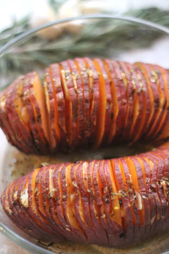  the cooked garlic oregano hasselback sweet potato in a glass ovenproof dish