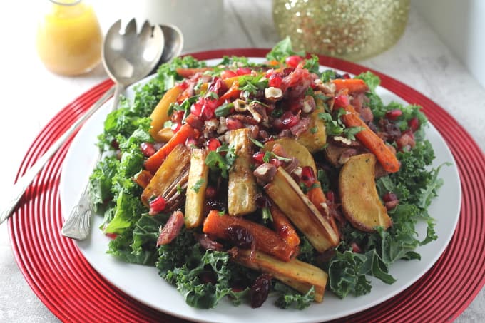 leftover christmas salad on a festive red and white plate with silver salad serving spoons on the side