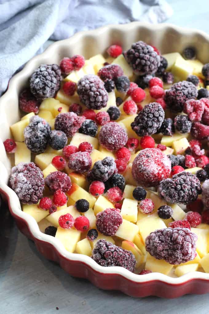 frozen strawberries, raspberries, blackberries, blackcurrants and redcurrants in the red ovenproof dish