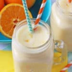 Close up of Orange Smoothie with orange and green straws