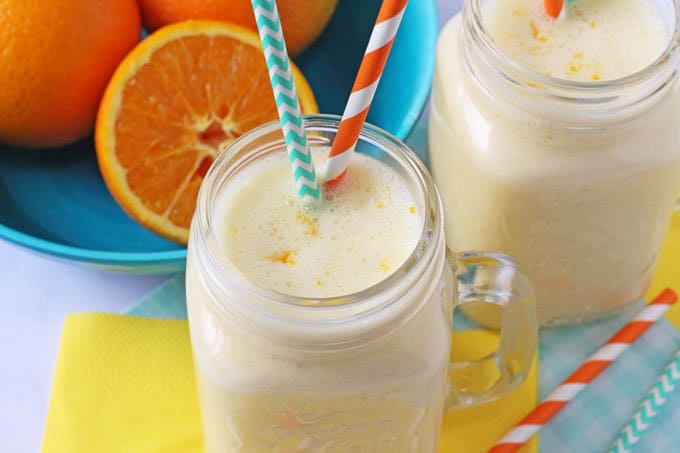 Close up of Orange Smoothie with orange and green straws