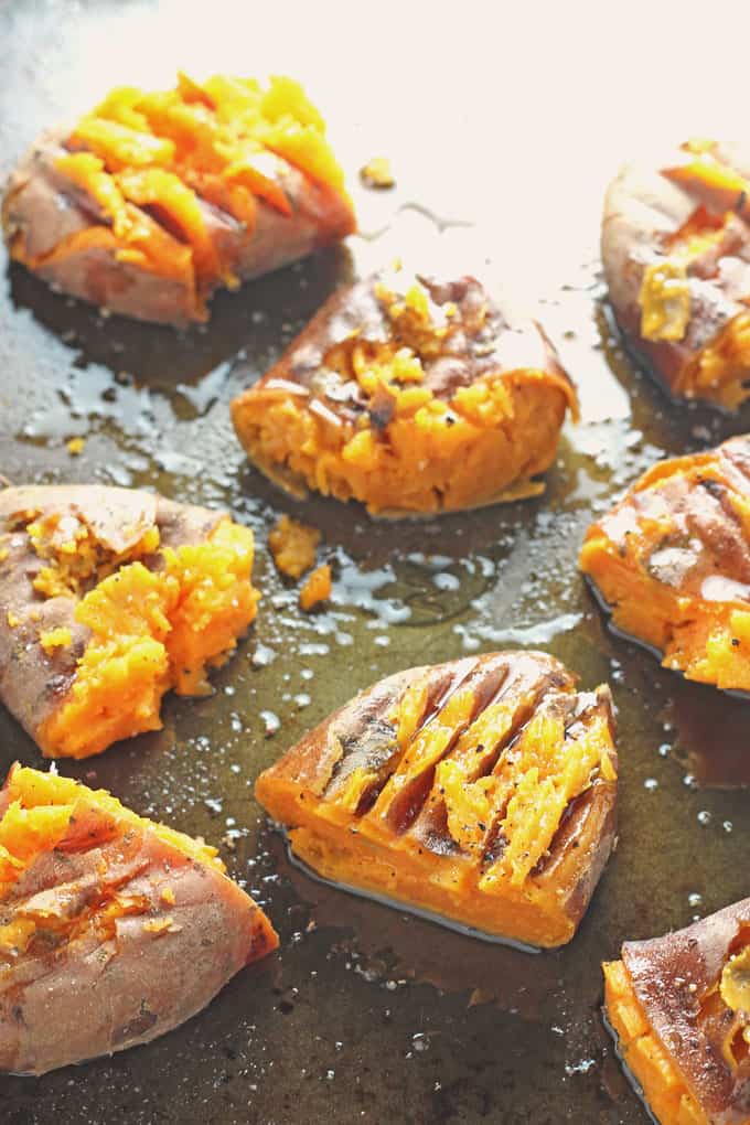the roasted smashed sweet potatoes drizzled with oil on a baking tray