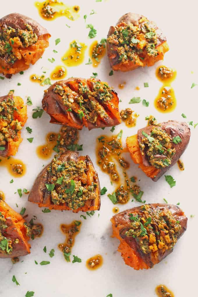 smashed sweet potatoes with pesto on a white marble background