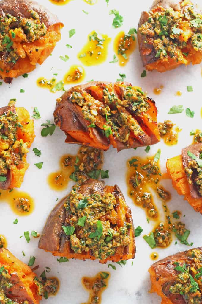 smashed sweet potatoes with pesto served on a white marble board