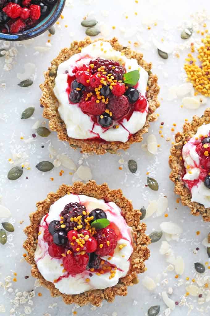 the finished breakfast tarts topped with fresh berries, nuts and seeds