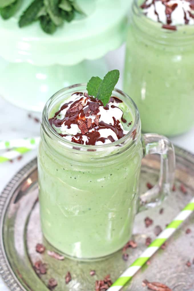 healthy shamrock shake topped with fresh mint, whipped coconut cream and a dark chocolate drizzle