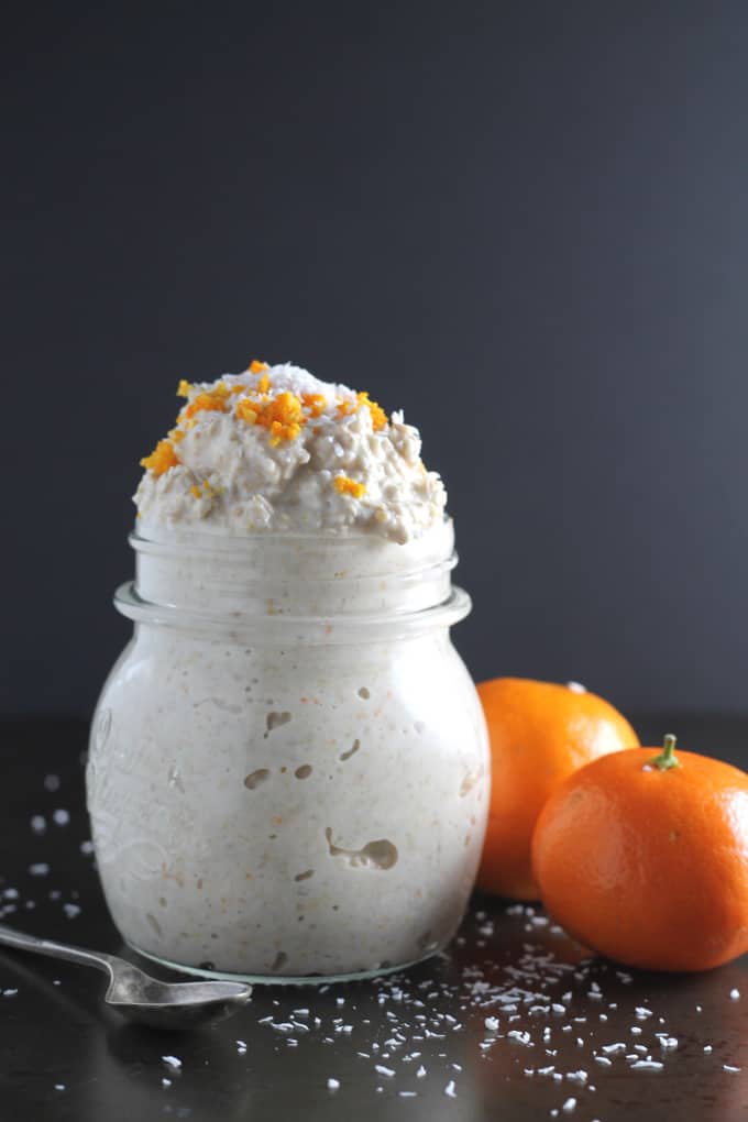 Orange, Coconut & Vanilla Overnight Oats in a glass jar topped with orange zest