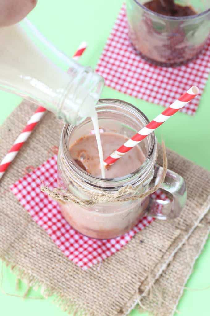 Milk being poured into the glass over the chocolate ice cubes