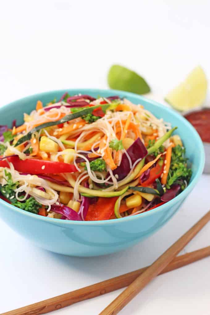 Veggie Rice Noodle Salad served in a blue bowl with a set wooden chopsticks in front of the bowl