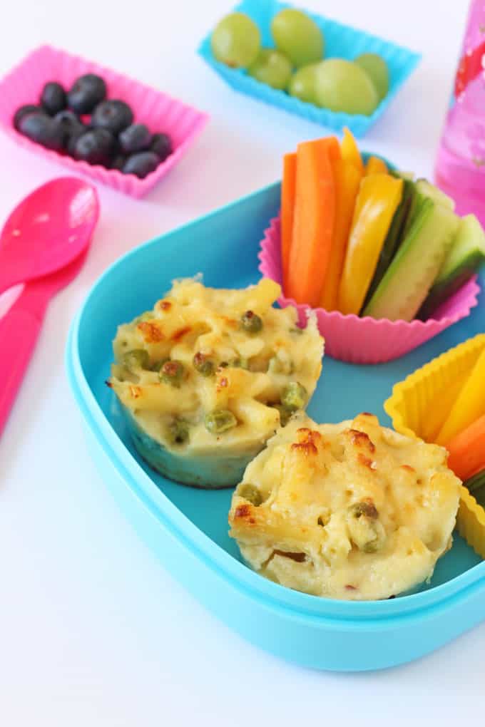 Mac n Cheese Muffins in a blue lunch box with chopped veggie sticks