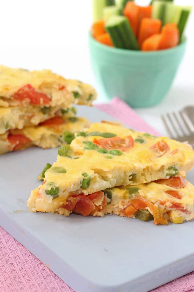 spanish omelette sliced on a blue chopping board