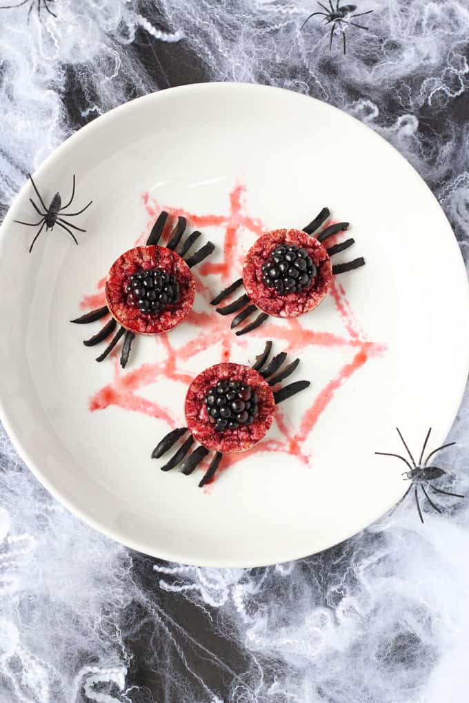 spooky spider rice cakes on a white plate on a cobweb background