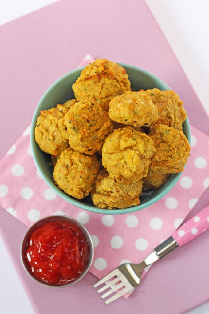 Veggie Meatballs for Kids for Kids served in a light green bowl with a pink polka dot napkin and a ramekin of tomato sauce.