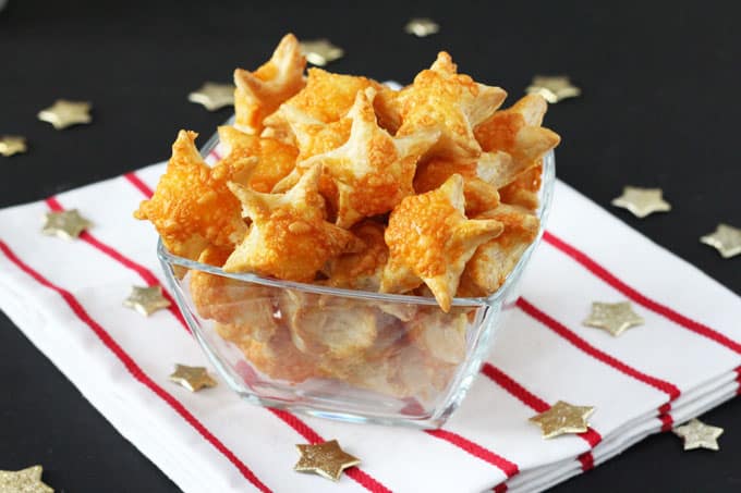 Cheesy Puff Pastry in a glass trencher on a red and white tea towel with gold stars scattered around