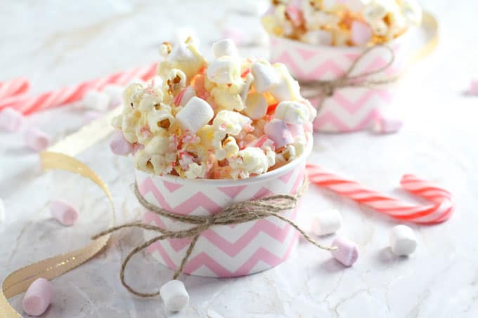 Candy Cane Popcorn with White Chocolate and Marshmallows in a small pink and white tub
