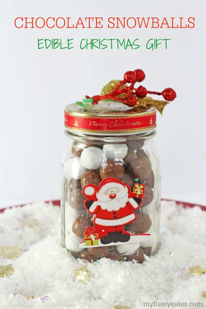 Chocolate Snowball treats in a glass jar decorated with Christmas decorations.