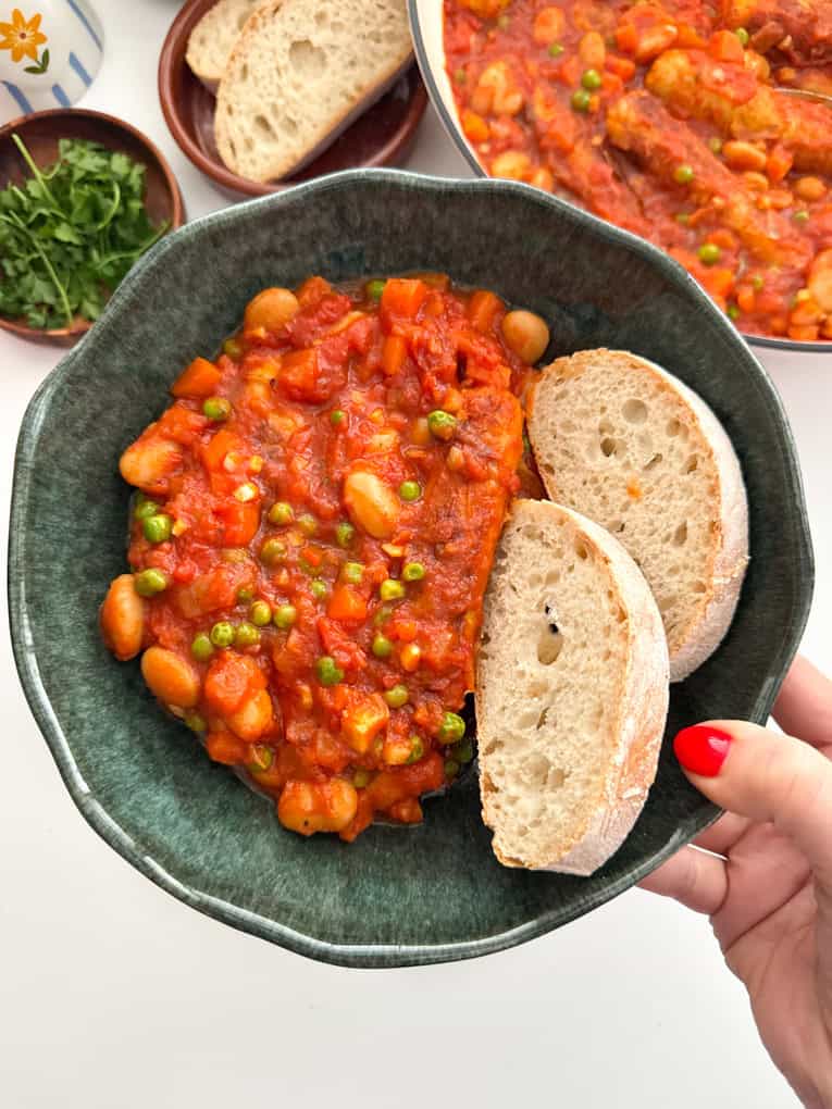 30 Minute Sausage and Bean Casserole in a green bowl with a serving of crusty bread.