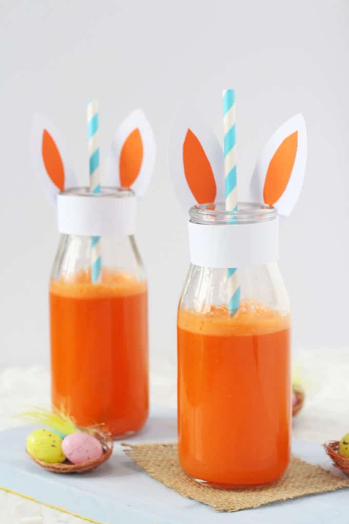 Carrot & Orange Juice served in small glass milk bottles with blue and white stripey straws. Decorated with bunny ears and 