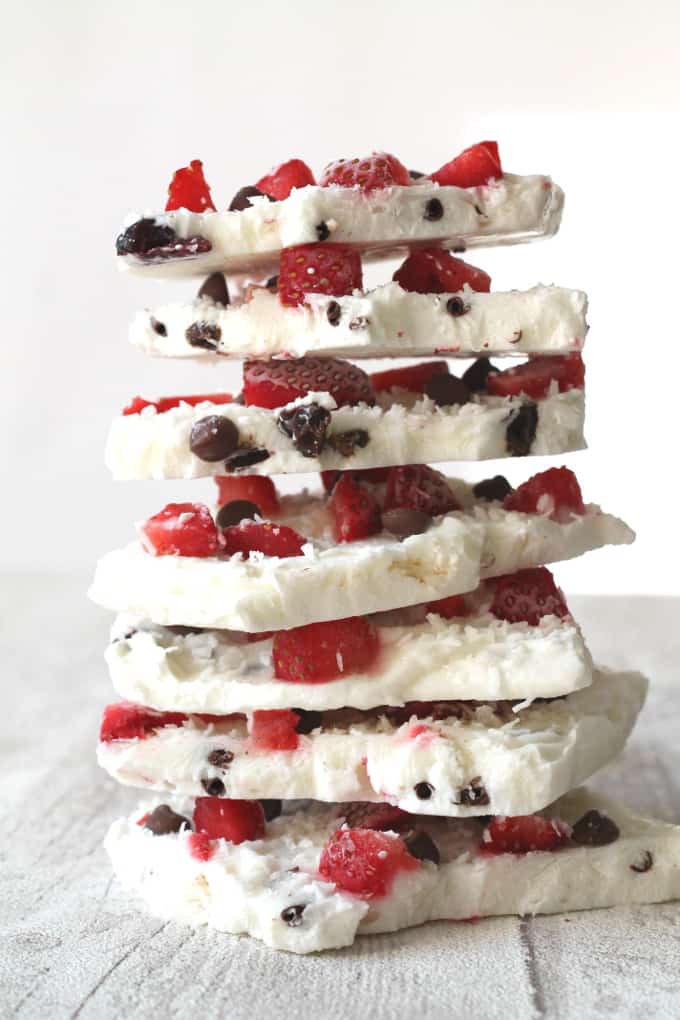 Frozen Yogurt Bark topped with strawberries and chocolate chips stacked into a tower