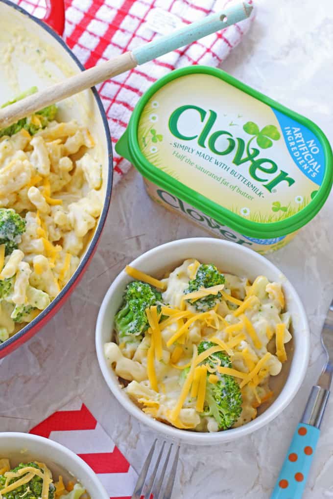 Broccoli Mac & Cheese in a small white bowl next to a tub of Clover buttermilk spread.