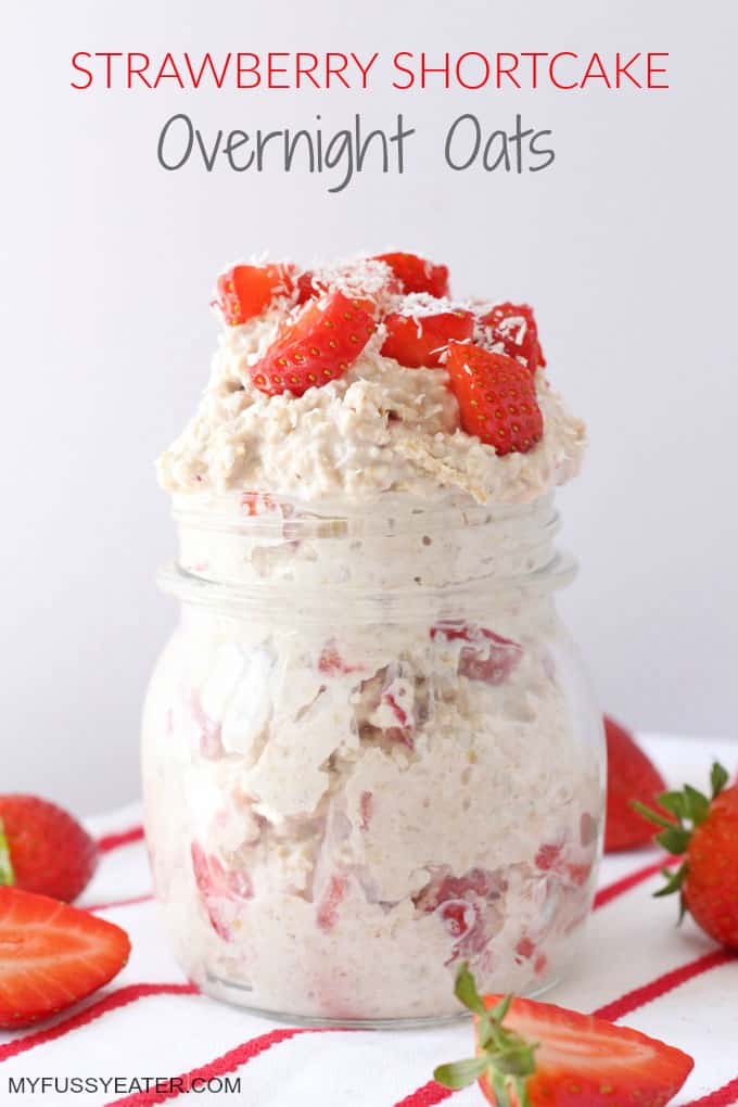 strawberry shortcake overnight oats in a glass jar and topped with sliced strawberries and desiccated coconut