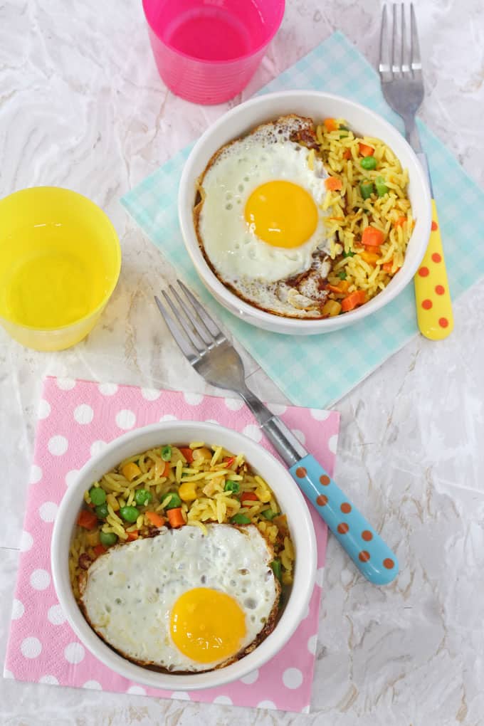 2 Vegetable Rice & Egg Bowls on napkins next to forks and coloured cups