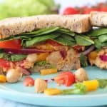 A delicious vegan sandwich packed with spicy sriracha chickpeas, lettuce, spinach, tomatoes and peppers. Perfect for a 2 minute healthy lunch for busy parents!