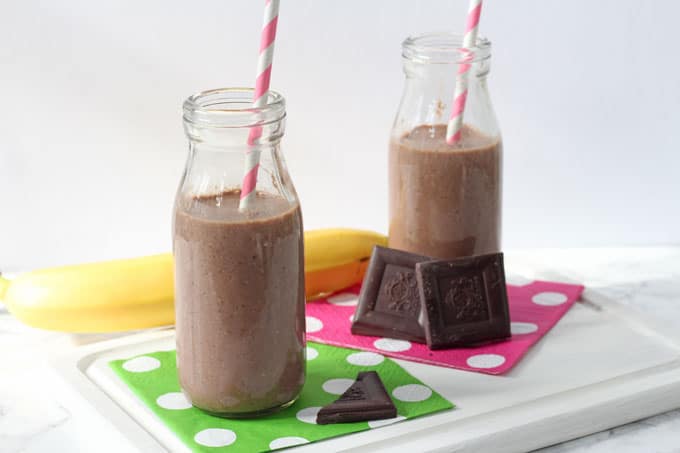 healthy chocolate shake for kids served in small glass milk bottles with candy stripe straws