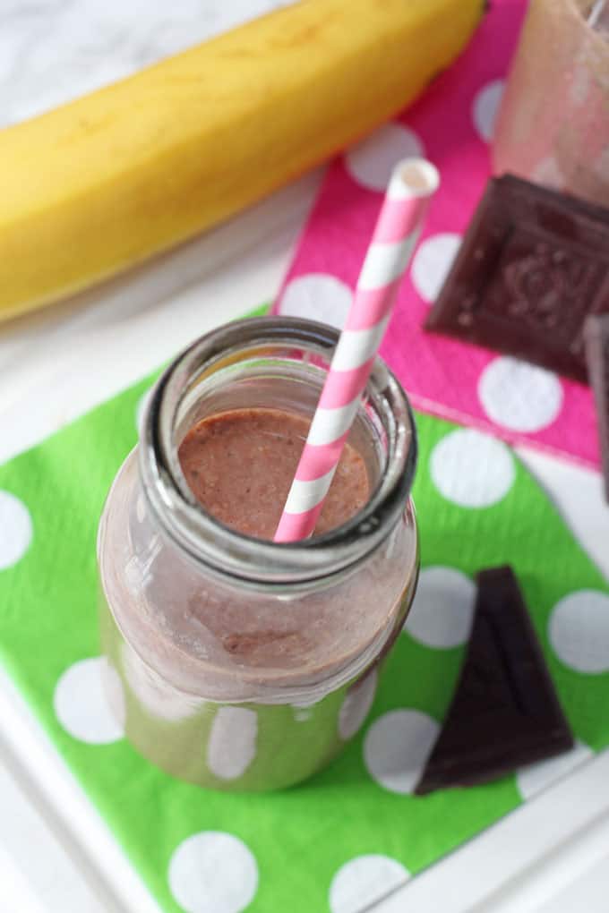 chocolate chia shake in a small milk bottle with a pink and white striped straw