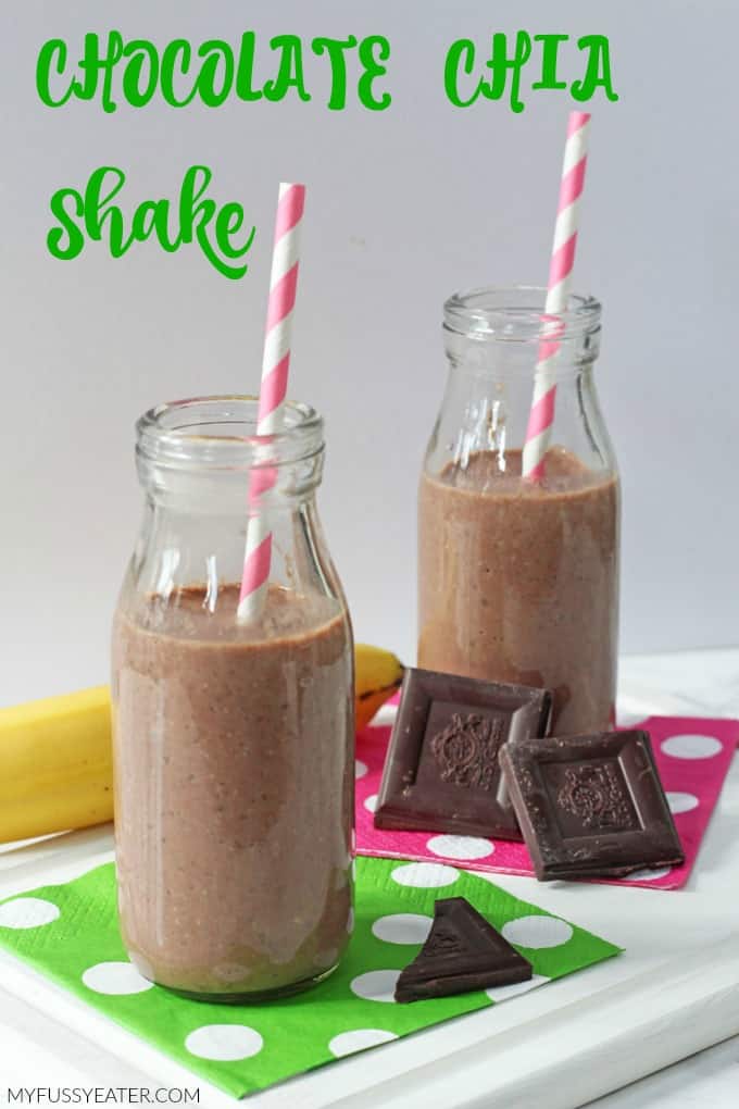 A healthy chocolate shake for kids packed with energy boosting chia seeds served in a small glass milk bottle with a candy striped straw.