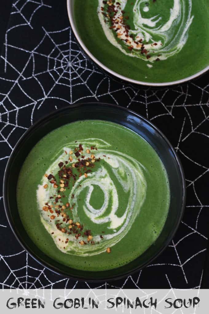 Two bowls of Green Goblin Spinach Soup on a black and white spider web tablecloth.