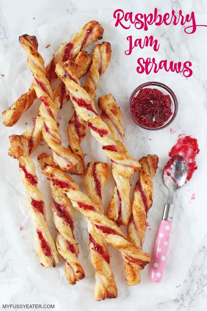 Raspberry Jam Straws on a marble board with a small pot of raspberry jam and a pink polka dot tea spoon