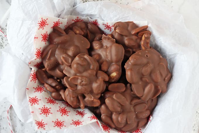 Chocolate Peanut Clusters in a basket with a festive  red and white snowflake napkin