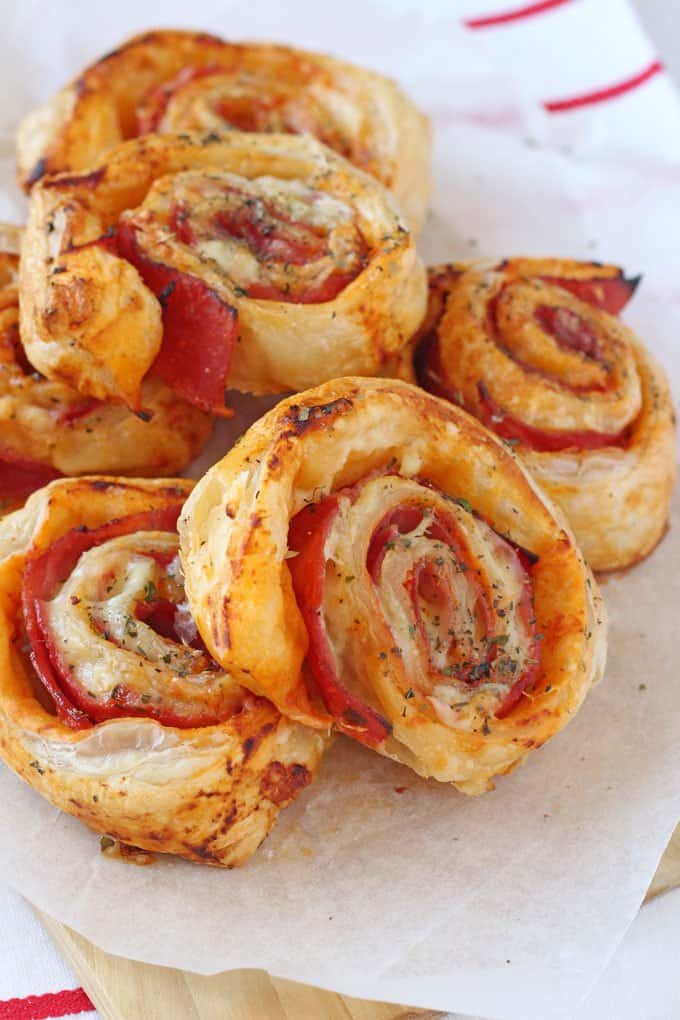 Easy Summer Lunches for Kids - Ham and cheese puff pastry rolls stacked on a wooden cutting board