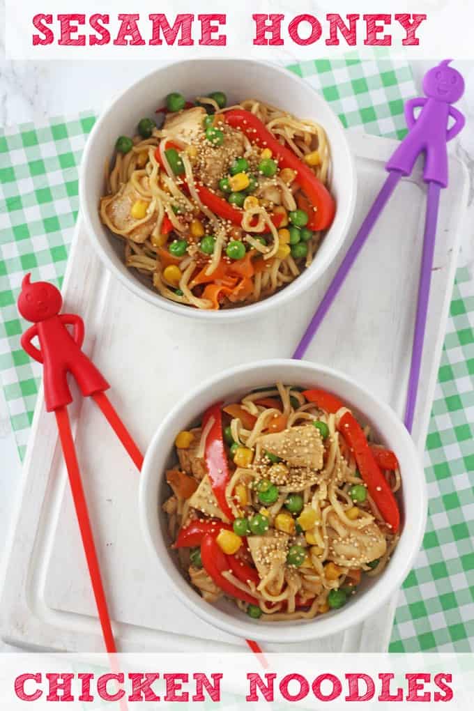 Sesame honey chicken noodles served in a white bowl and garnished with sesame seeds and chopped veggies.