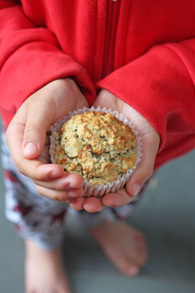 child holding banana & avocado baby muffin