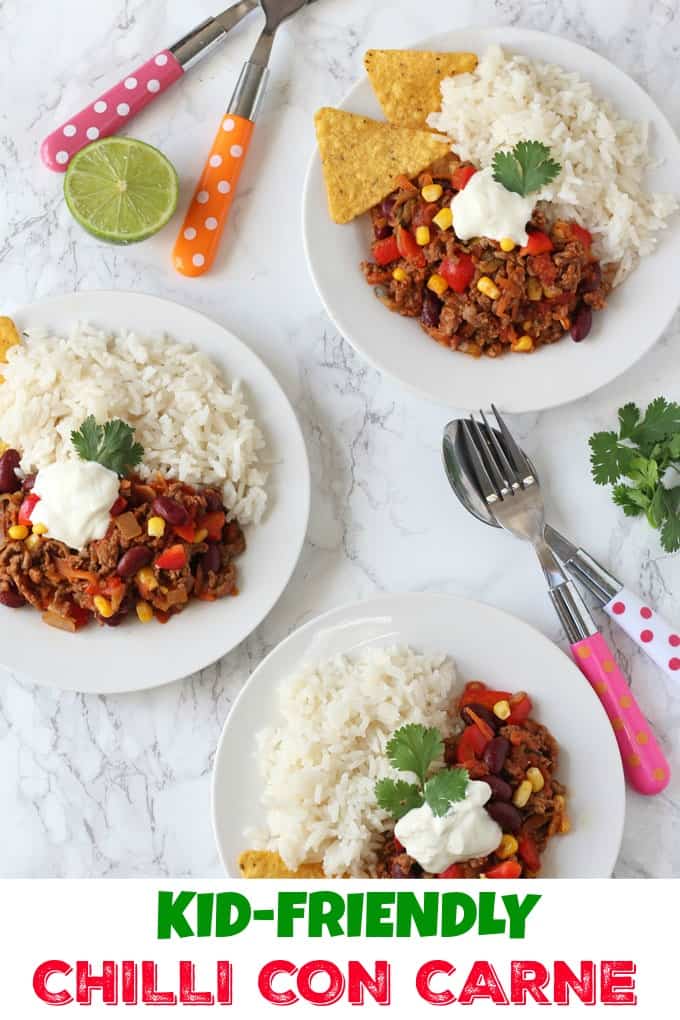 Kid friendly chilli con carne, served on a white dinner plate, accompanied by fluffy white rice and tortilla chips