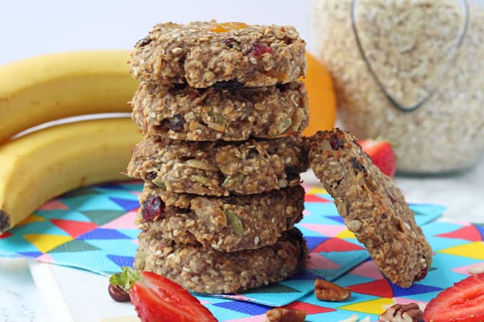Easy Breakfast Recipes and Ideas to Prep for Kids - Fruit and nut breakfast cookies stacked in a pile, with a jar of oatmeal and a bunch of bananas in the background