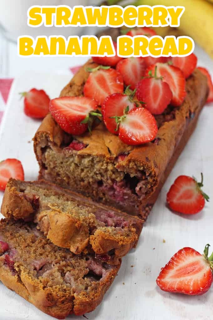 A loaf of strawberry banana bread that has been sliced and topped with fresh chopped strawberries.