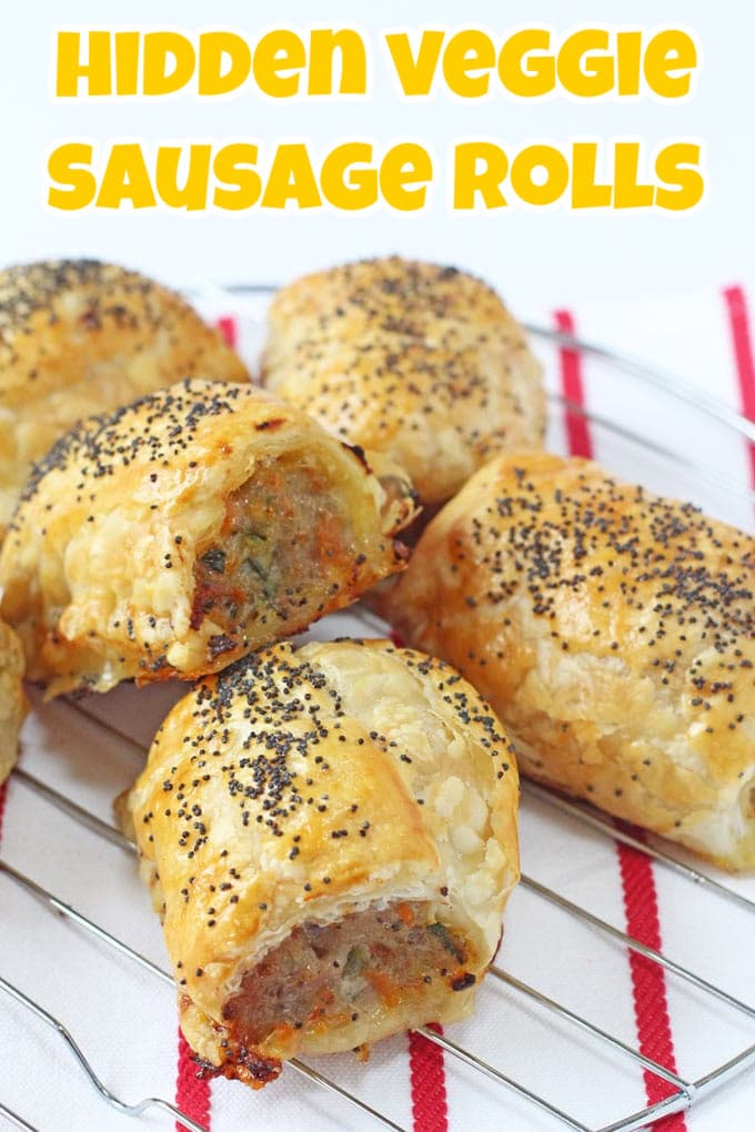 Hidden Veggie Sausage Rolls stacked on a wire cooling rack on top of a red and white striped tea towel.