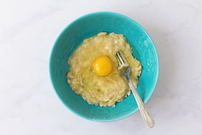 Blue bowl with mashed banana and egg