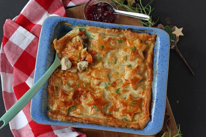 Turkey, Cranberry & Brie Pie with a puff pastry top decorated with pastry stars in a blue oven proof dish