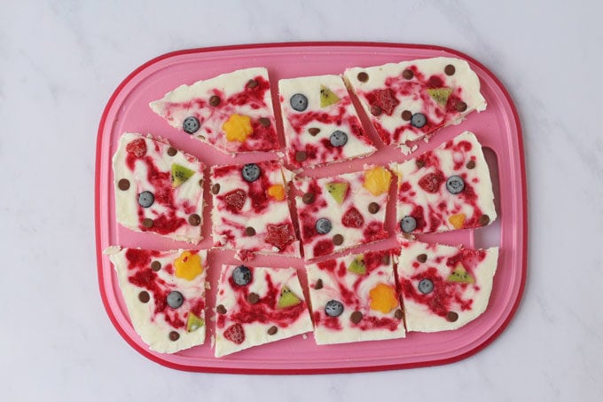raspberry ripple yogurt bark on a pink and red chopping board